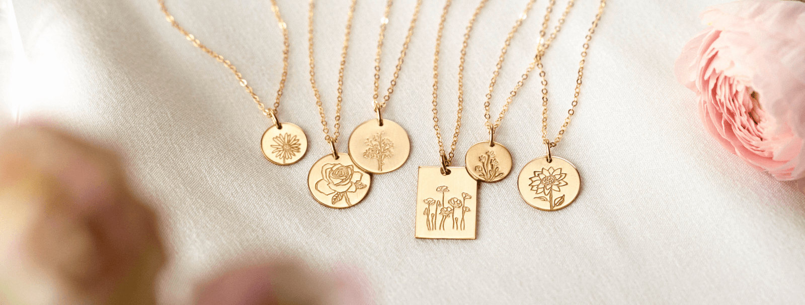 Gold floral pendant necklaces with dainty chains.